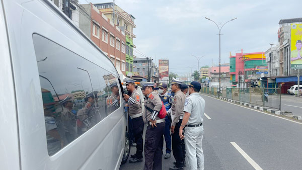 Personil Ditlantas Polda Sumut saat melakukan operasi penindakan mobil penumpang plat hitam di Jalan Sisingamangaraja Medan.