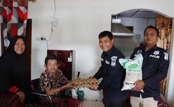 Kasi Humas Polres Dairi Ipda Ringkom Manik bersama personil Bripka Junaidi dan Briptu Oktavianus Panjaitan, menyerahkan bantuan sosial sembako kepada Amsar Marbun.