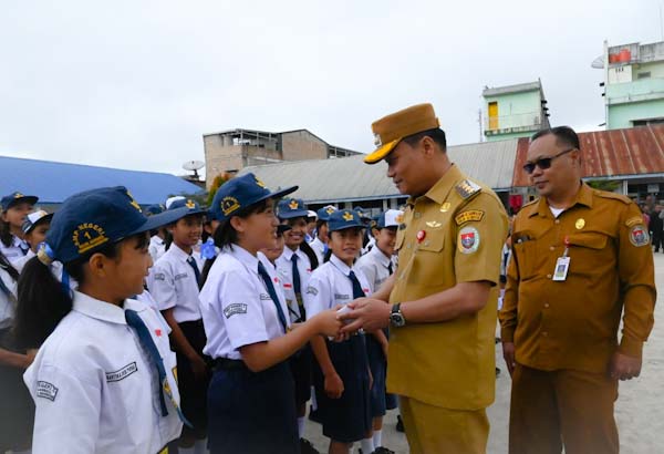 Bupati Humbahas Oloan Paniaran Nababan didampingi Plt Kadis Pendidikan Martahan Panjaitan menyalami siswa-siswi usai pelaksanaan upacara.