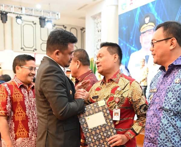 Bupati Humbang Hasundutan, Oloan Paniaran Nababan secara simbolis menerima Dana Bagi Hasil (DBH) dari Gubernur Sumut Bobby Nasution.