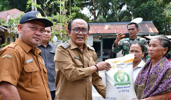 Wakil Bupati Samosir, Ariston Tua Sidauruk saat menyerahkan bantuan Cadangan Pangan Pemerintah (CPP)